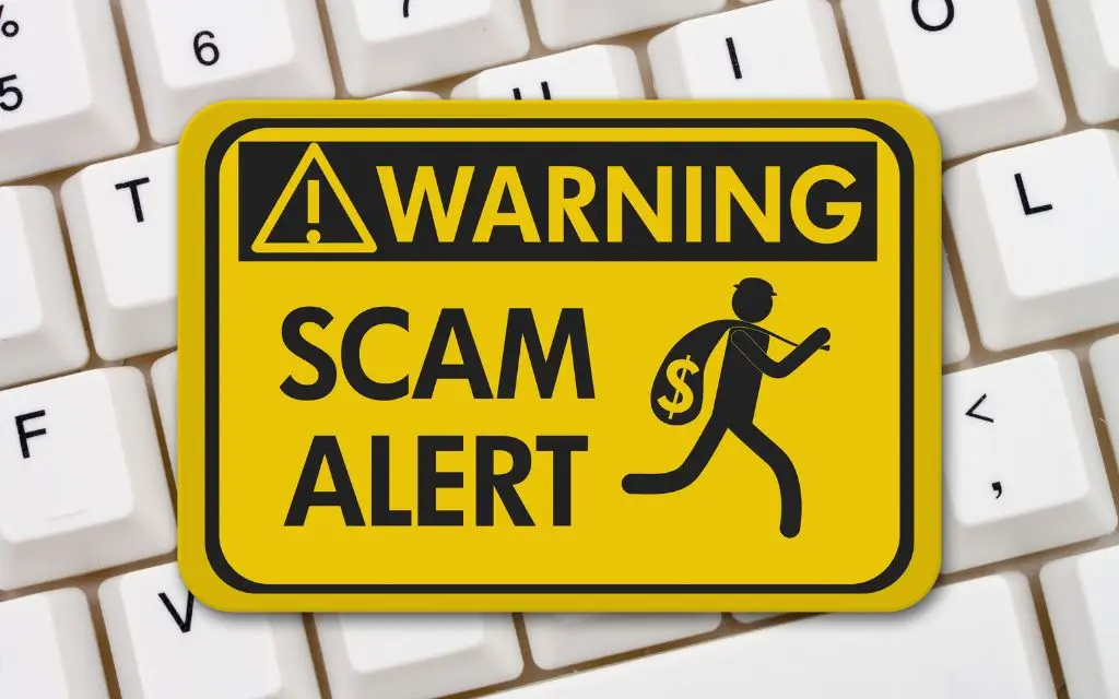 Black and Yellow Job scam Alert sign with a keyboard underneath, illustrating the content on how to avoid job scams
