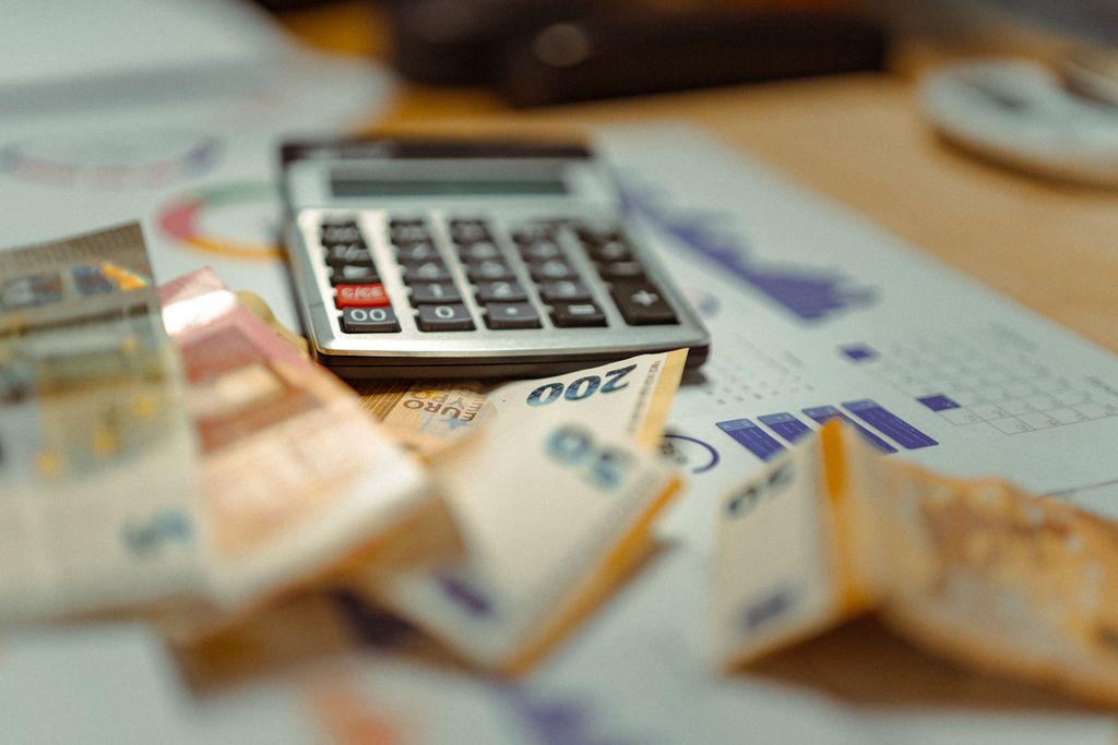 Why Pay Range, Schedule, And Location Matter In Job Postings 2 Euro banknotes and calculator on financial documents, focusing on business budget planning.